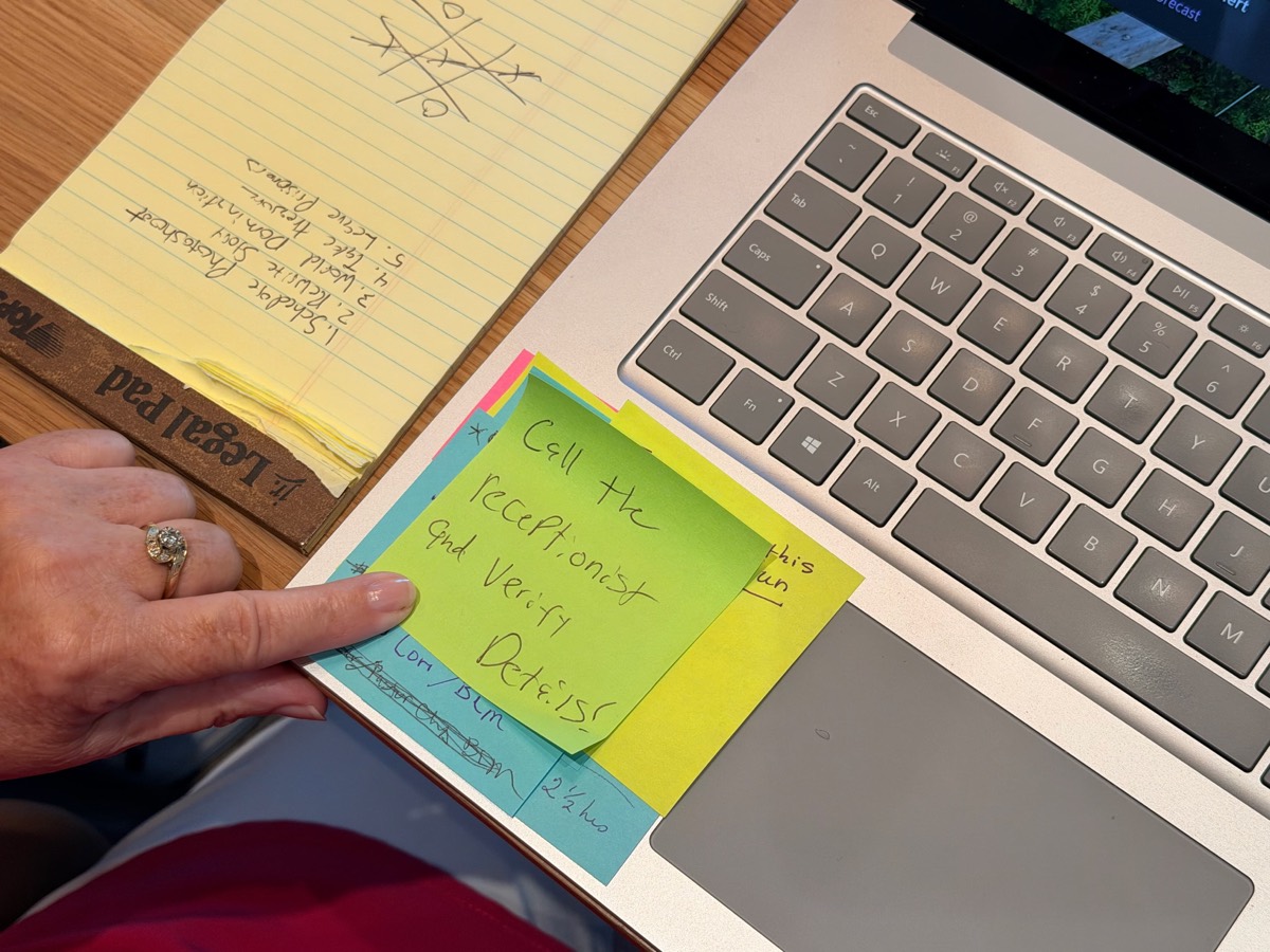 A handwritten sticky note reminder on a laptop: the raw material