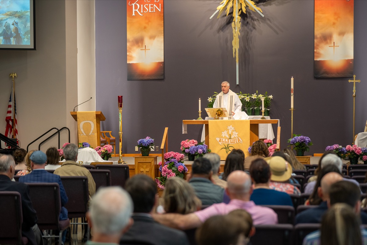 A full sanctuary at Epiphany Lutheran during Easter worship, flowers lining the altar